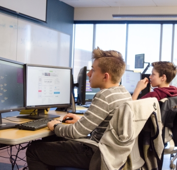 Student in class, with two monitors